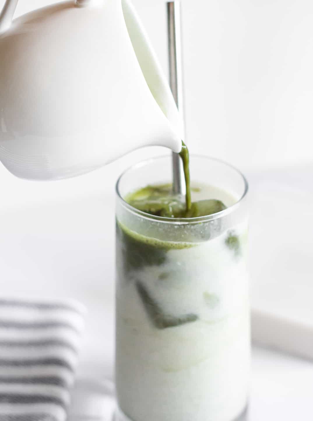 Premium Photo  Two glasses of iced matcha green tea mixed with ice cubes  and milk in high glasses on kitchen table cold matcha latte in home  interior green mocktail with ice